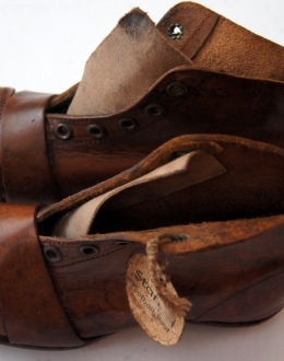 Brytyjskie buty dziecięce do gry w piłkę nożną lub rugby. Wykonane z brązowej skóry, posiadające drewnianą podeszwę i drewniano-skórzane kolce (po 6 na każdym bucie). Buty są szyte, posiadają wzmocnienia wykonane z kawałków skóry. Podeszwa i korki zamocowane są za pomocą gwoździ. Na podeszwie widoczny numer buta: ,,11". Lewy but opatrzony jest etykietką producenta: ,,The Stanley Football Boot".