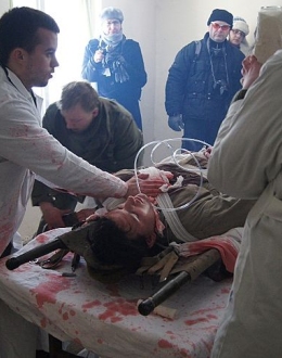 Sanitariusze w punkcie opatrunkowym podczas opatrywania rannego.