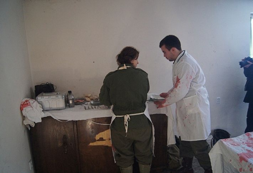Sanitariusze udzielający pomocy rannemu żołnierzowi.