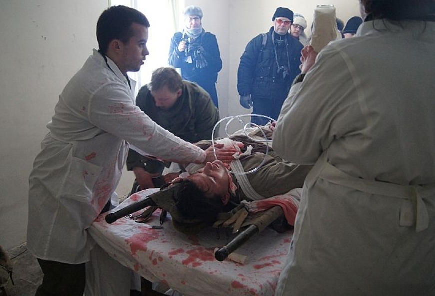 Sanitariusze w punkcie opatrunkowym podczas opatrywania rannego.