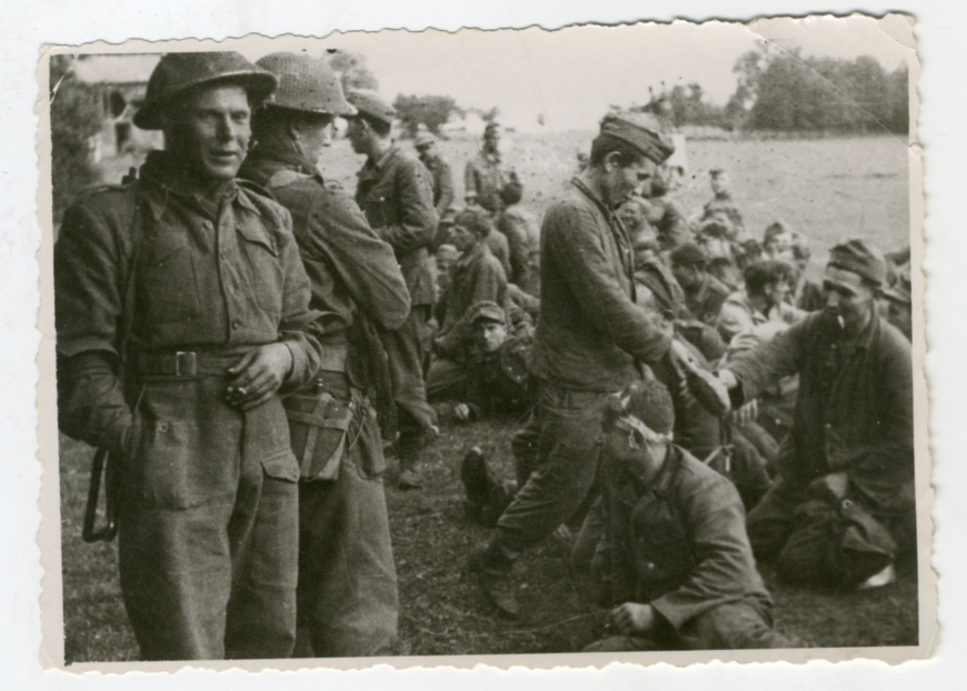 Fot. Żołnierze 1. Dywizji Pancernej wraz z niemieckimi jeńcami po walkach stoczonych w Normandii (MIIWŚ/dar Stefana Galikowskiego)