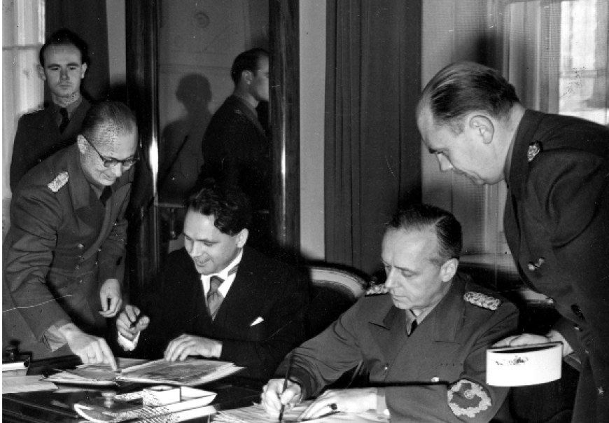 Zdj. Podpisanie układu niemiecko-słowackiego przez ministra spraw zagranicznych III Rzeszy Joachima von Ribbentropa (drugi z prawej) i posła słowackiego w Berlinie Matusza Cernaka (trzeci z prawej), Berlin 1939 (Źródło: Narodowe Archiwum Cyfrowe).