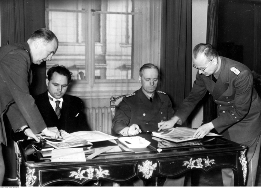 Minister spraw zagranicznych III Rzeszy Joachim von Ribbentrop (drugi z prawej) i poseł słowacki w Berlinie Matusz Cernak (drugi z lewej) podpisują układ niemiecko-słowacki. Widoczny również poseł Paul Schmidt (pierwszy z lewej), Berlin, 21 XI 1939 (Narodowe Archiwum Cyfrowe)