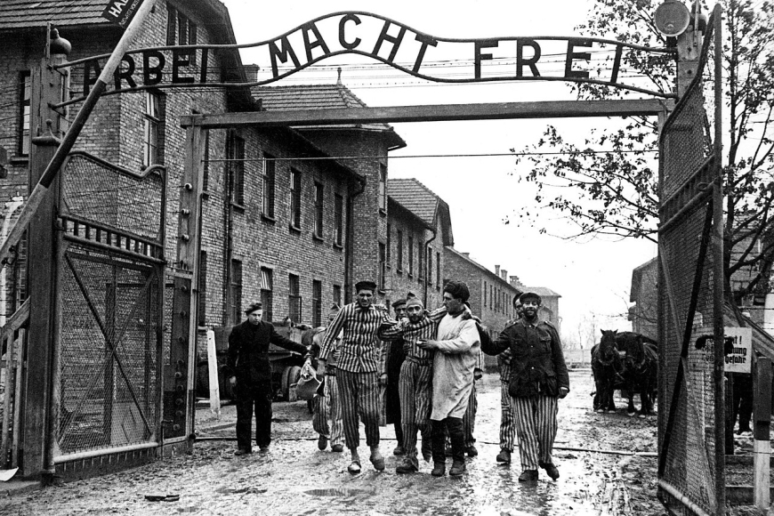 Więźniowie przekraczają bramę KL Auschwitz (Źródło: Domena publiczna)