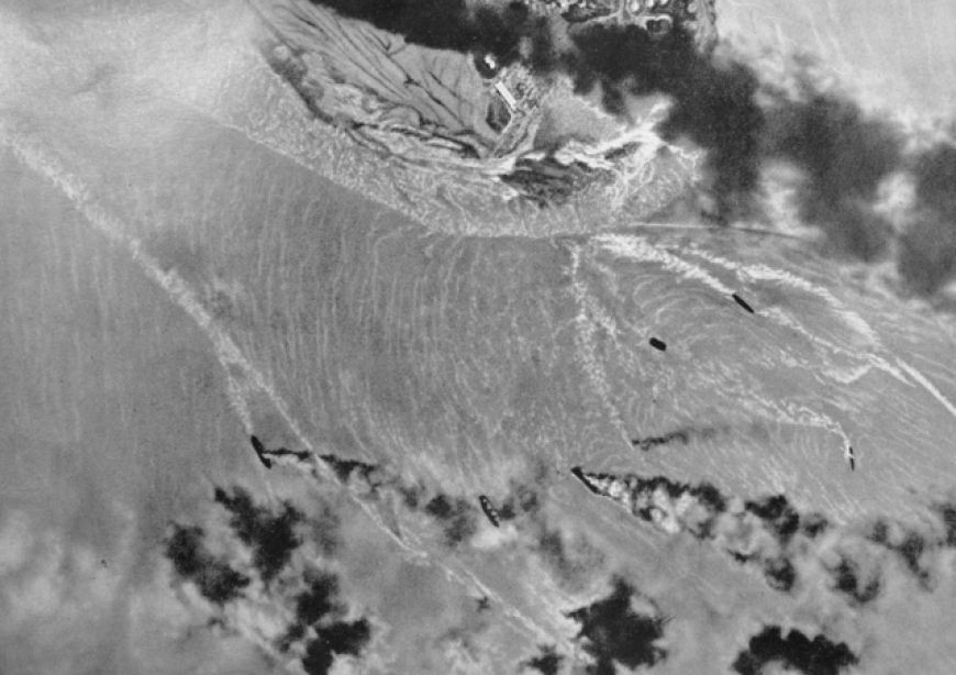 Zniszczone, płonące jednostki w porcie Darwin. Zdjęcie wykonane przez nieznanego pilota japońskiego. 19 lutego 1942 r. (domena publiczna)