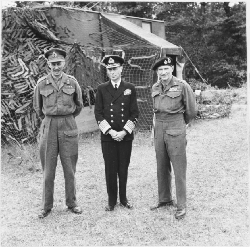 Król Wielkiej Brytanii Jerzy VI z gen. Milesem Dempseyem i gen. Bernardem Montgomerym (pierwszy z prawej). 16 czerwca 1944 r. (domena publiczna)