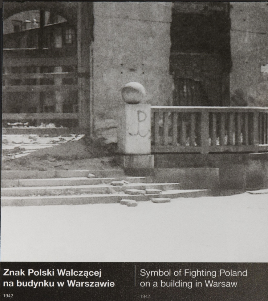 Znak Polski Walczącej namalowany przez „Alka” Dawidowskiego na balustradzie werandy kawiarni Lardellego. Fotografię można zobaczyć na wystawie głównej MIIWŚ w dziale poświęconym oporowi przeciwko okupantom. Źródło: MIIWŚ/AAN