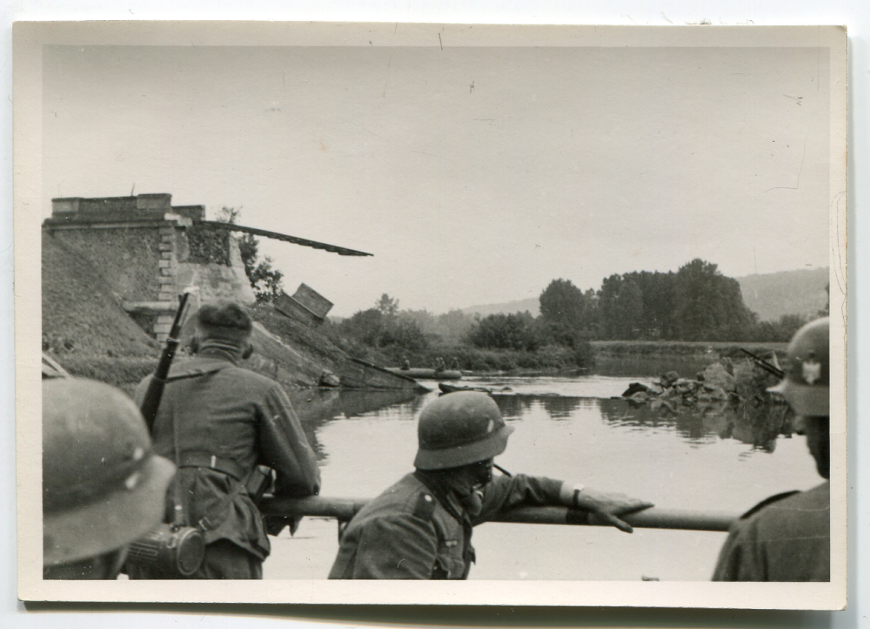 Niemieccy żołnierze forsujący rzekę w Belgii/Francji w maju/czerwcu 1940 r. W tle widoczny zniszczony most kolejowy. Zbiory MIIWŚ w Gdańsku
