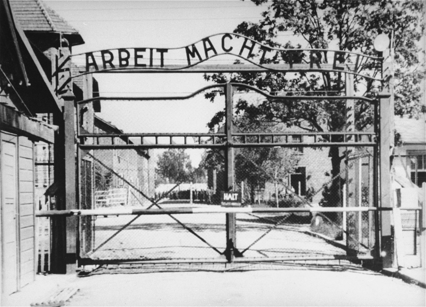 Fot. 1. Widok na wejście do głównego obozu Auschwitz (Auschwitz I). Napis na bramie „Arbeit Macht Frei” (pol. praca czyni wolnym). 1945 r. (IPN)