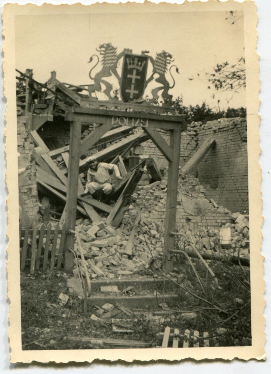 Zdjęcie przedstawiające zniszczony posterunek niemieckiej policji zlokalizowany przy bramie drogowej prowadzącej na teren Westerplatte. To najprawdopodobniej w jej pobliżu poległ kpr. Kowalczyk. Autor nieznany, Westerplatte, wrzesień 1939 r. (MIIWŚ)