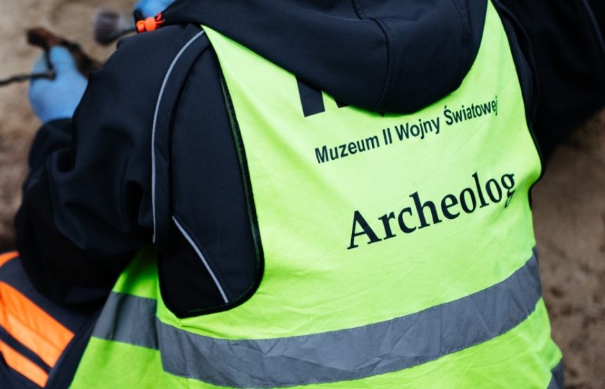 Archeolog Muzeum II Wojny Światowej podczas prac wykopaliskowych